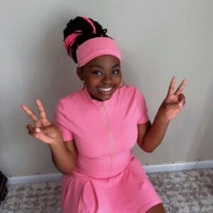Pink three-piece skirt set with zip-front crop top and biker shorts